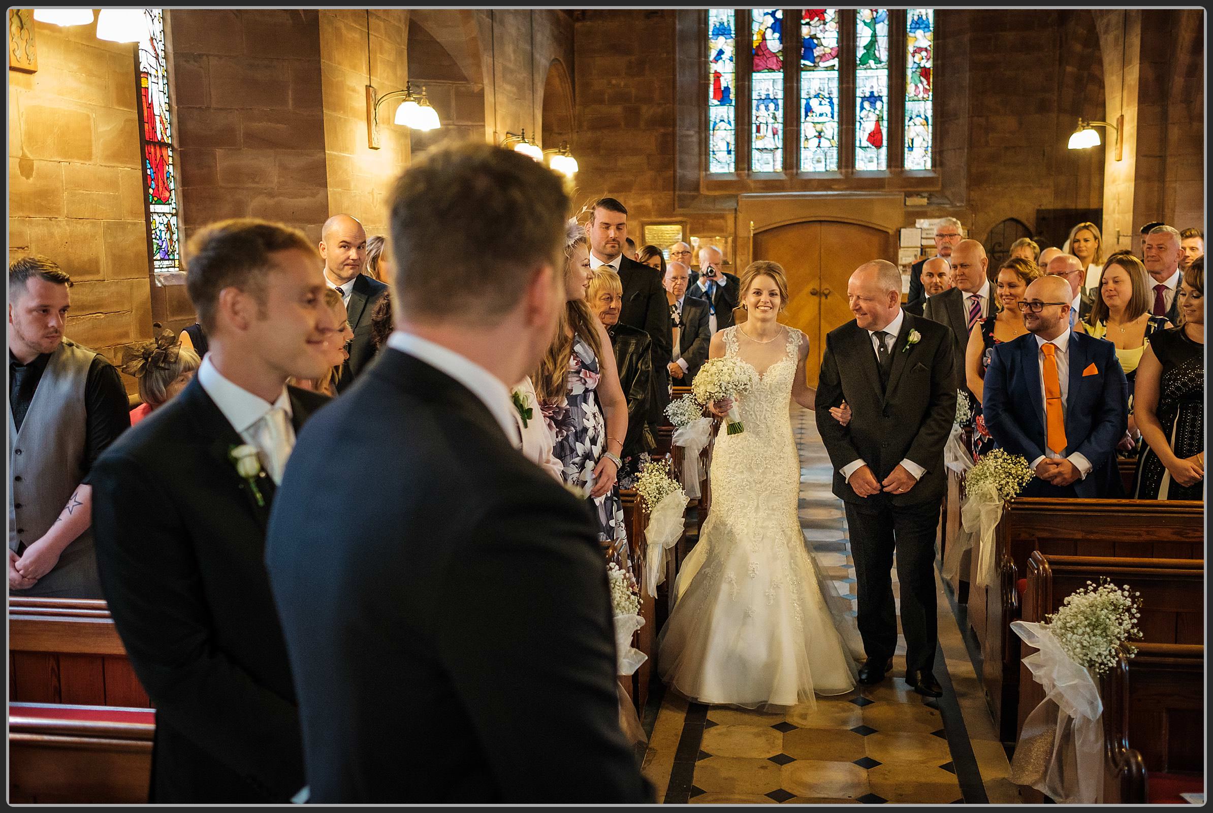Bride walking down the aisle at St Peter's Church