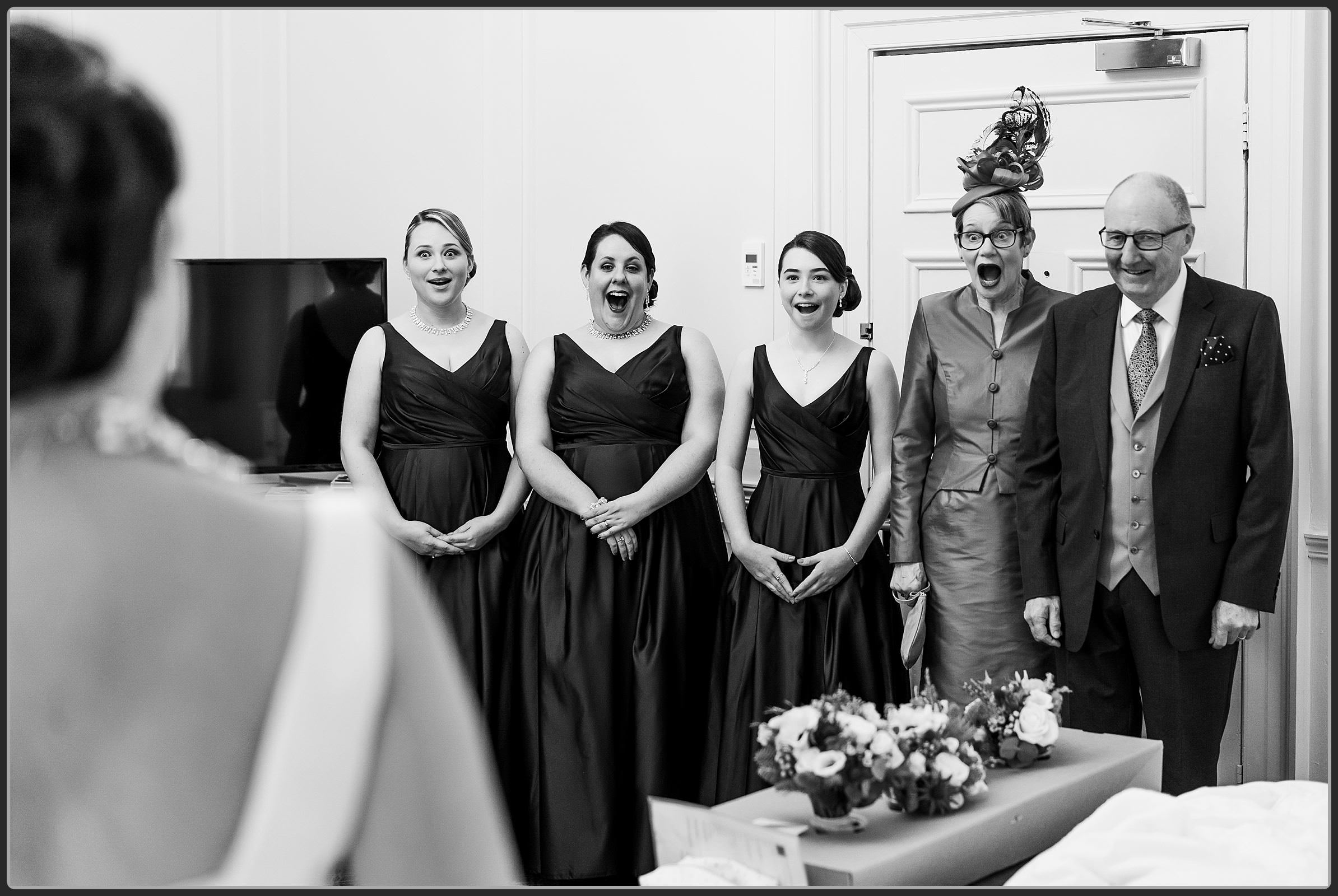 Bridesmaids and brides parents reaction to the bride in her dresss