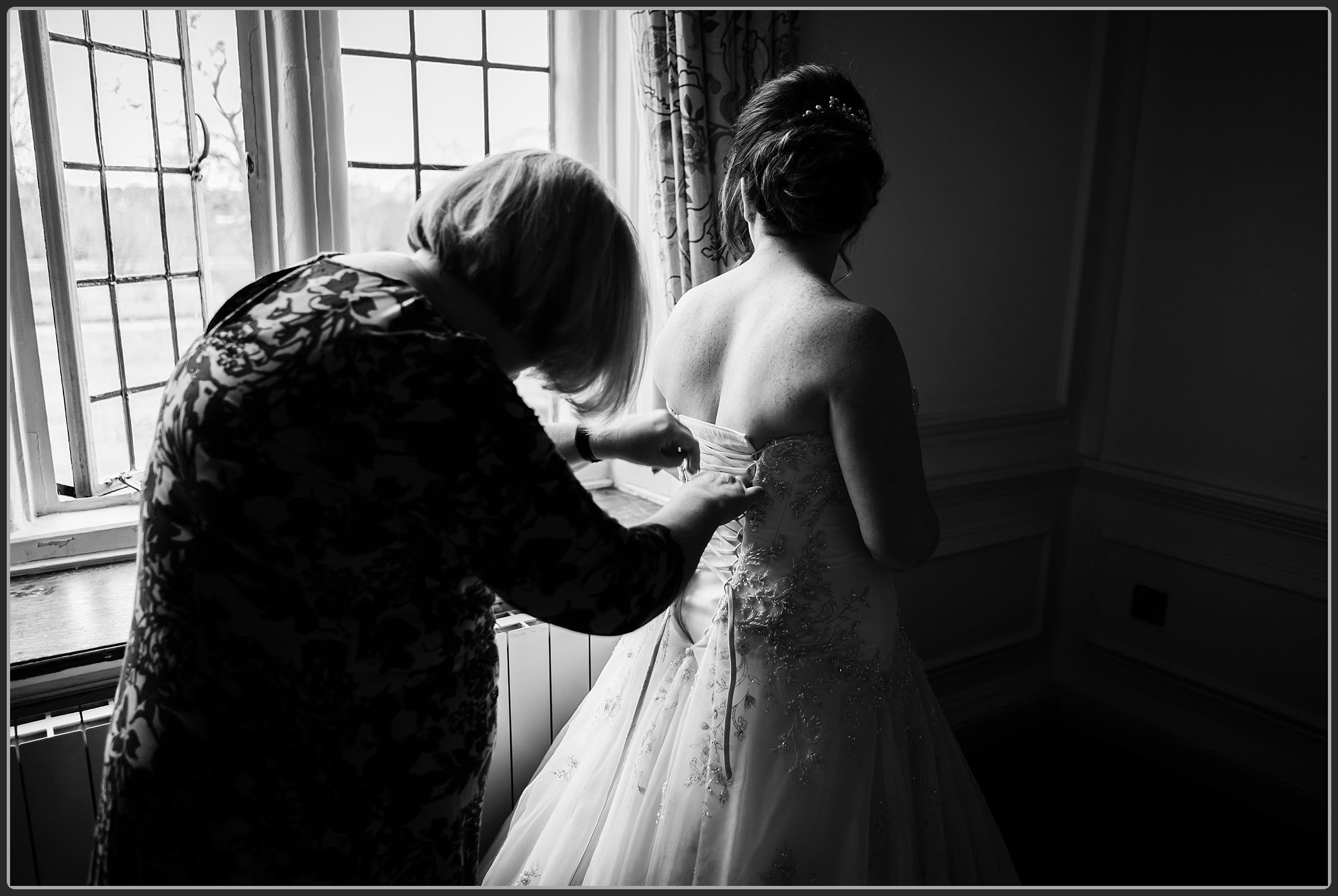 The bride having her dress done up