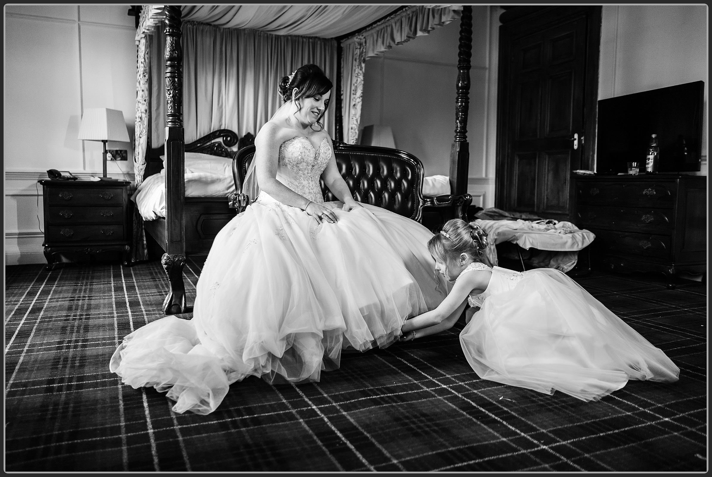 The flower girl putting the brides shoes on