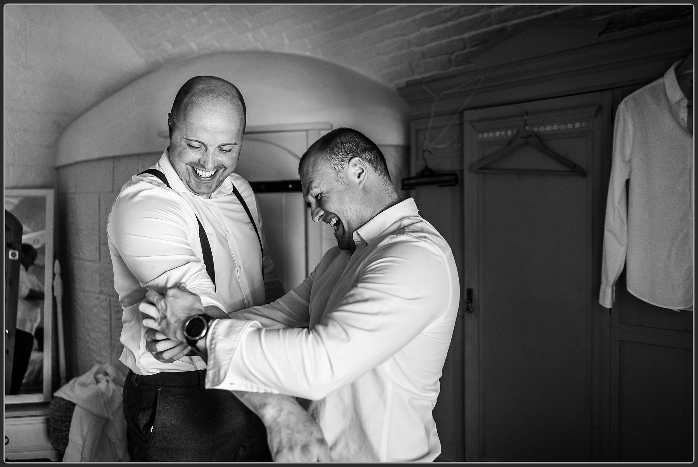 Best man helping the groom get changed