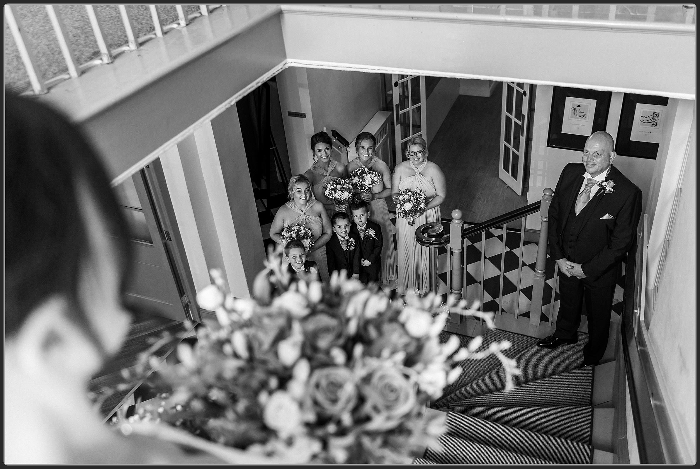 The brides father seeing her for the first time on the stairs at Warwick House