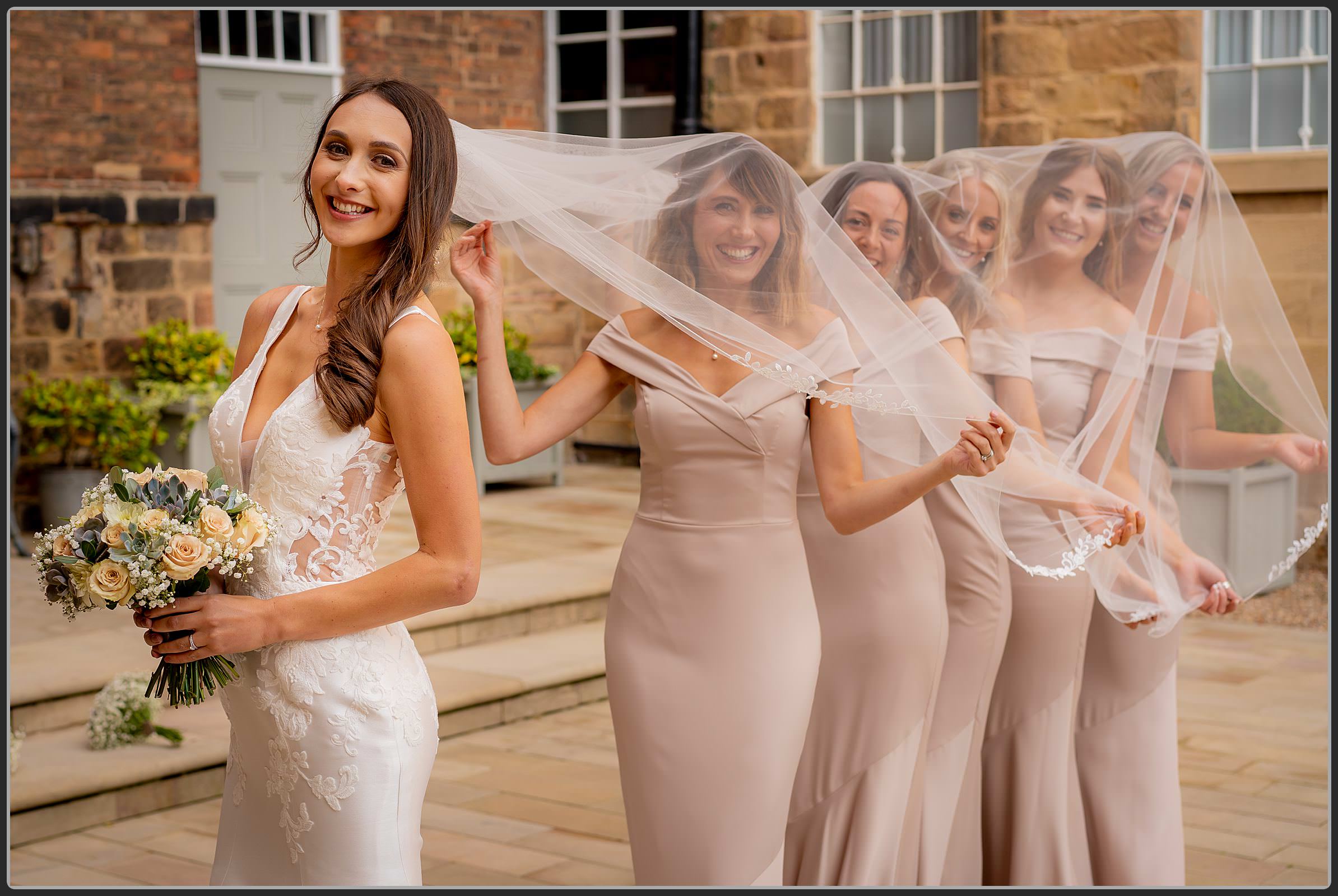 Bridesmaids under the brides veil