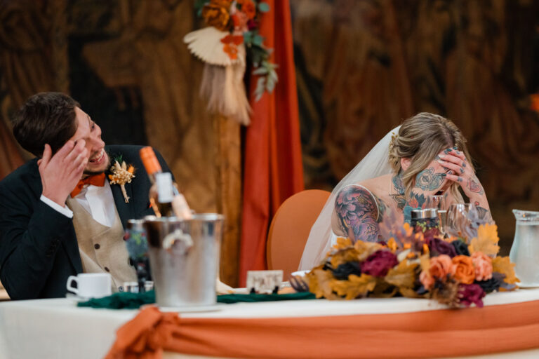 Bride and groom laughing during the best man's speech