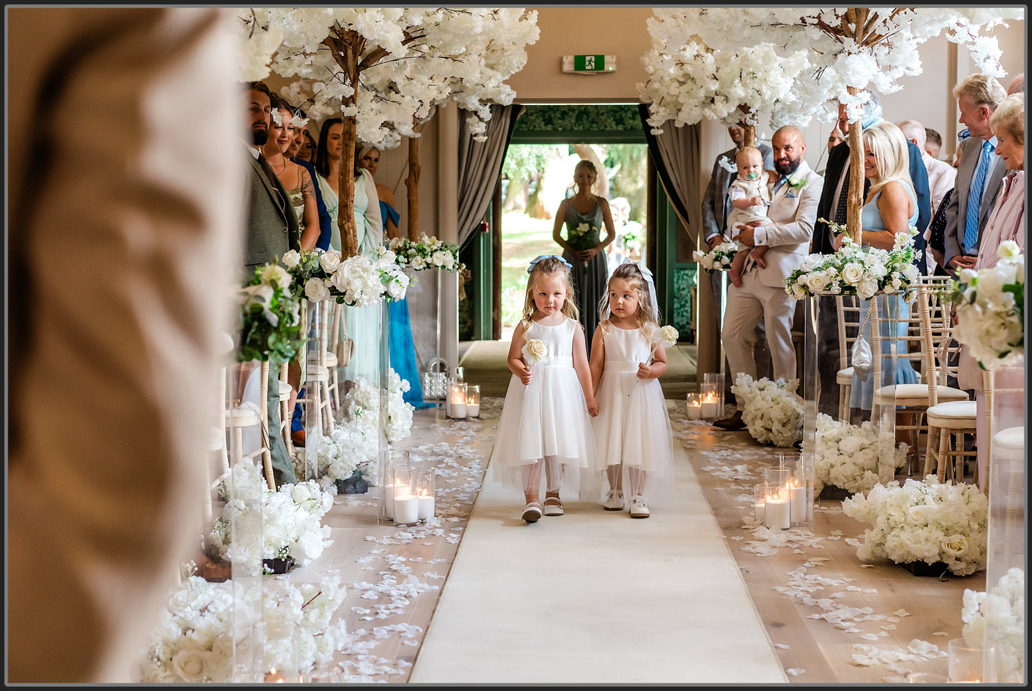 The flower girls walking down the isle at Hampton Manor