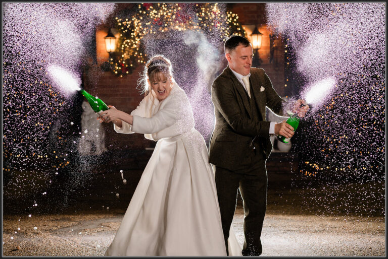 Bride and groom spraying champagne outside Ardencote Manor Hotel