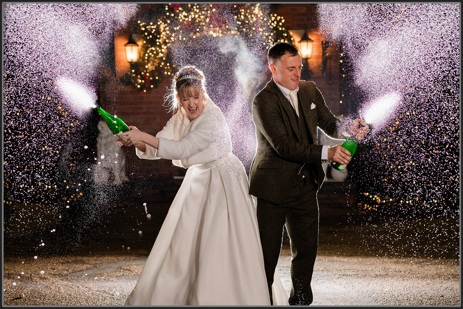 Bride and groom spraying champagne outside Ardencote Manor Hotel