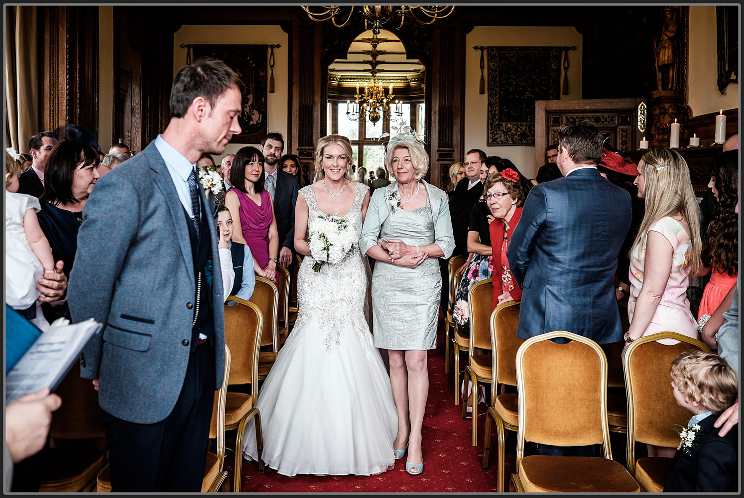 The bride walking down the isle at Fawsley Hall Hotel